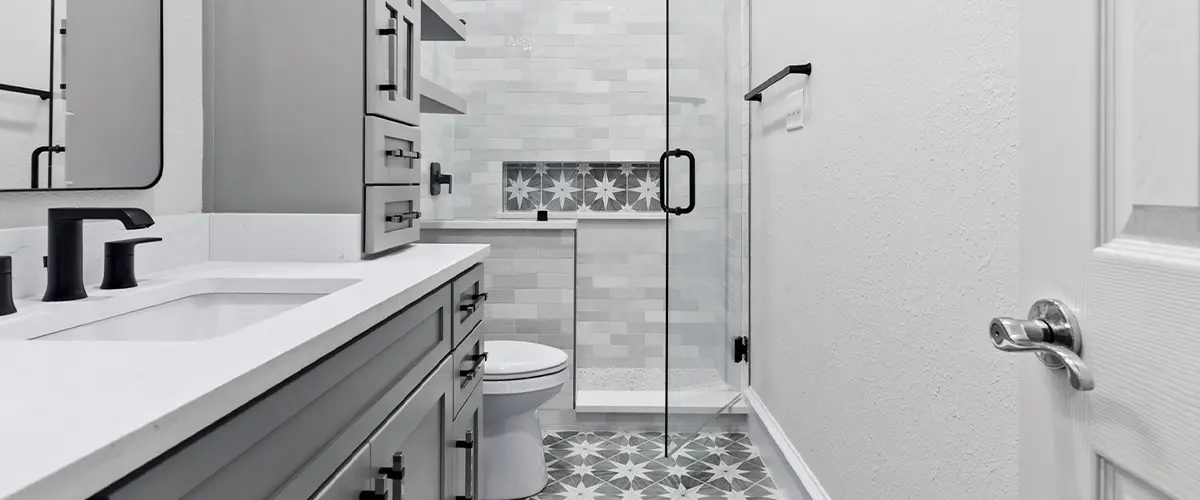 Contemporary bathroom renovation with black fixtures, glass shower, and custom cabinetry.