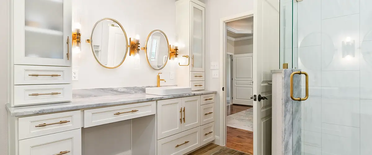 Luxury bathroom remodel with gold accents, glass shower, and custom cabinetry for modern home design.