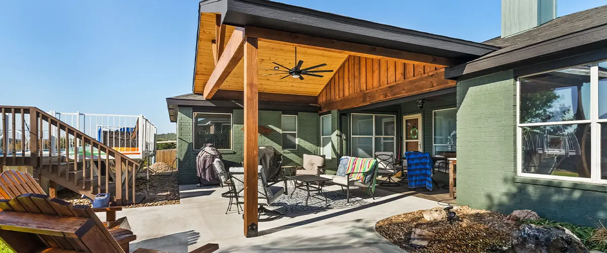 Modern outdoor patio with wood pergola, seating area, and backyard pool, ideal for outdoor living.