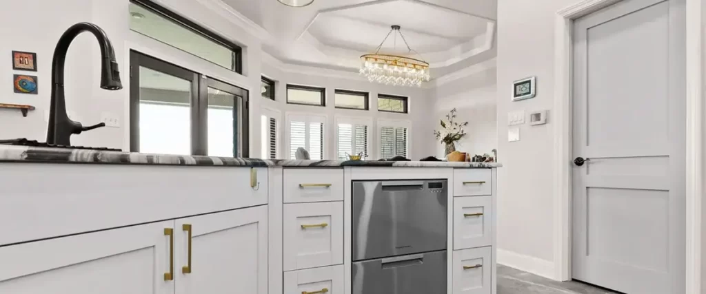 Spacious kitchen island with white cabinetry, gold hardware, and elegant pendant lighting. Stylish kitchen remodel inspiration.