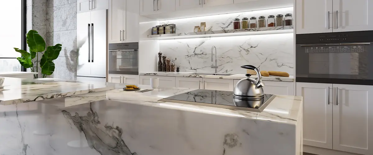 Luxury kitchen with marble countertops and backsplash, white cabinetry, under-cabinet lighting, and modern decor