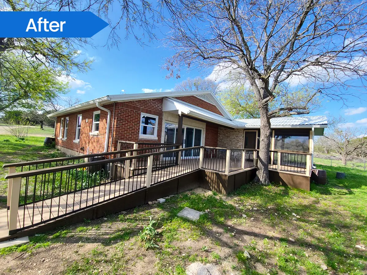 Rear view of a house with an accessible wooden deck and a sloped walkway.