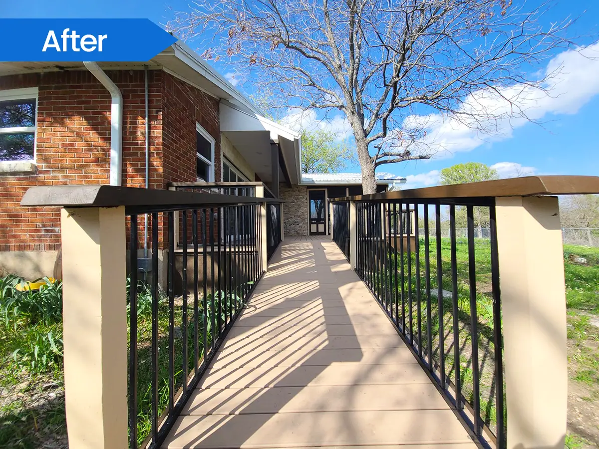 Side view of a wooden ramp with black railings for easy backyard access.