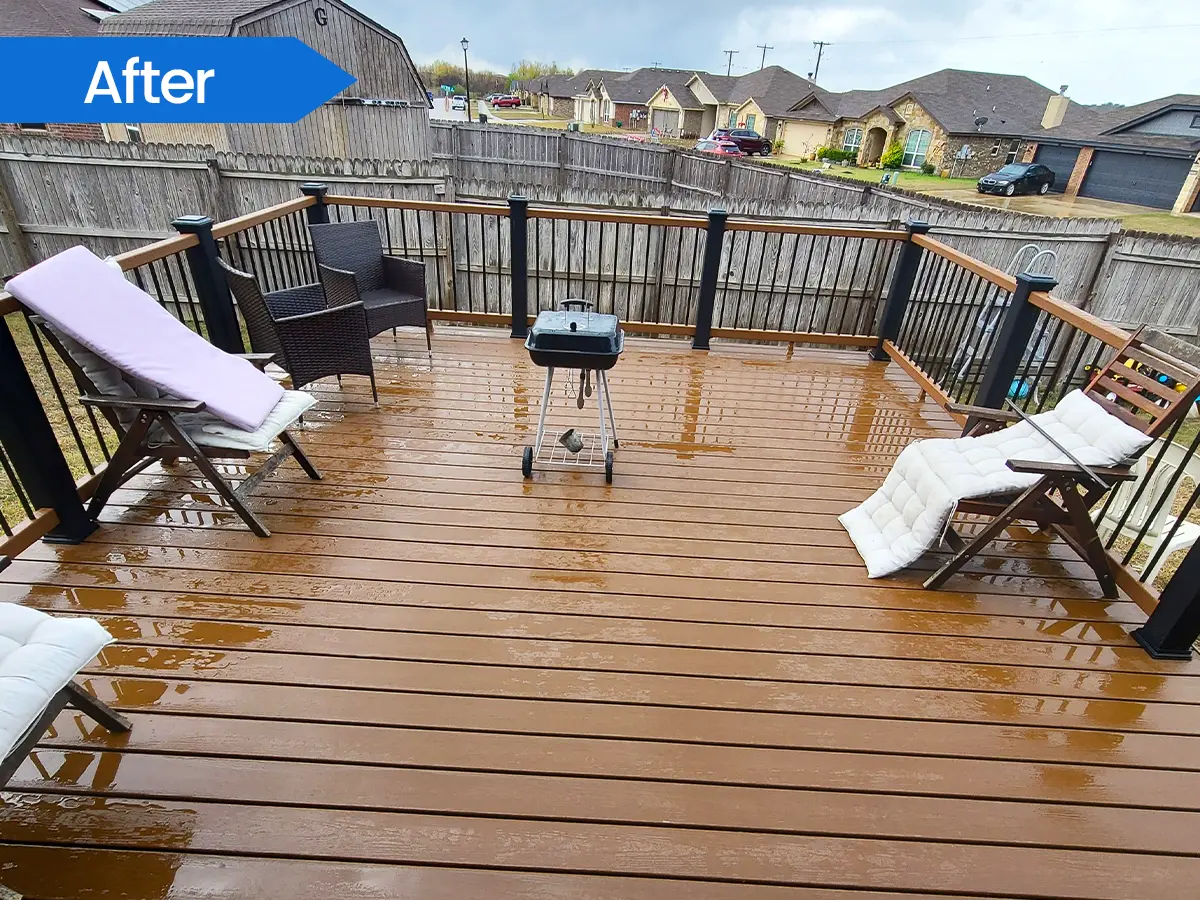 Spacious wooden deck with patio furniture and black railings overlooking a residential neighborhood.