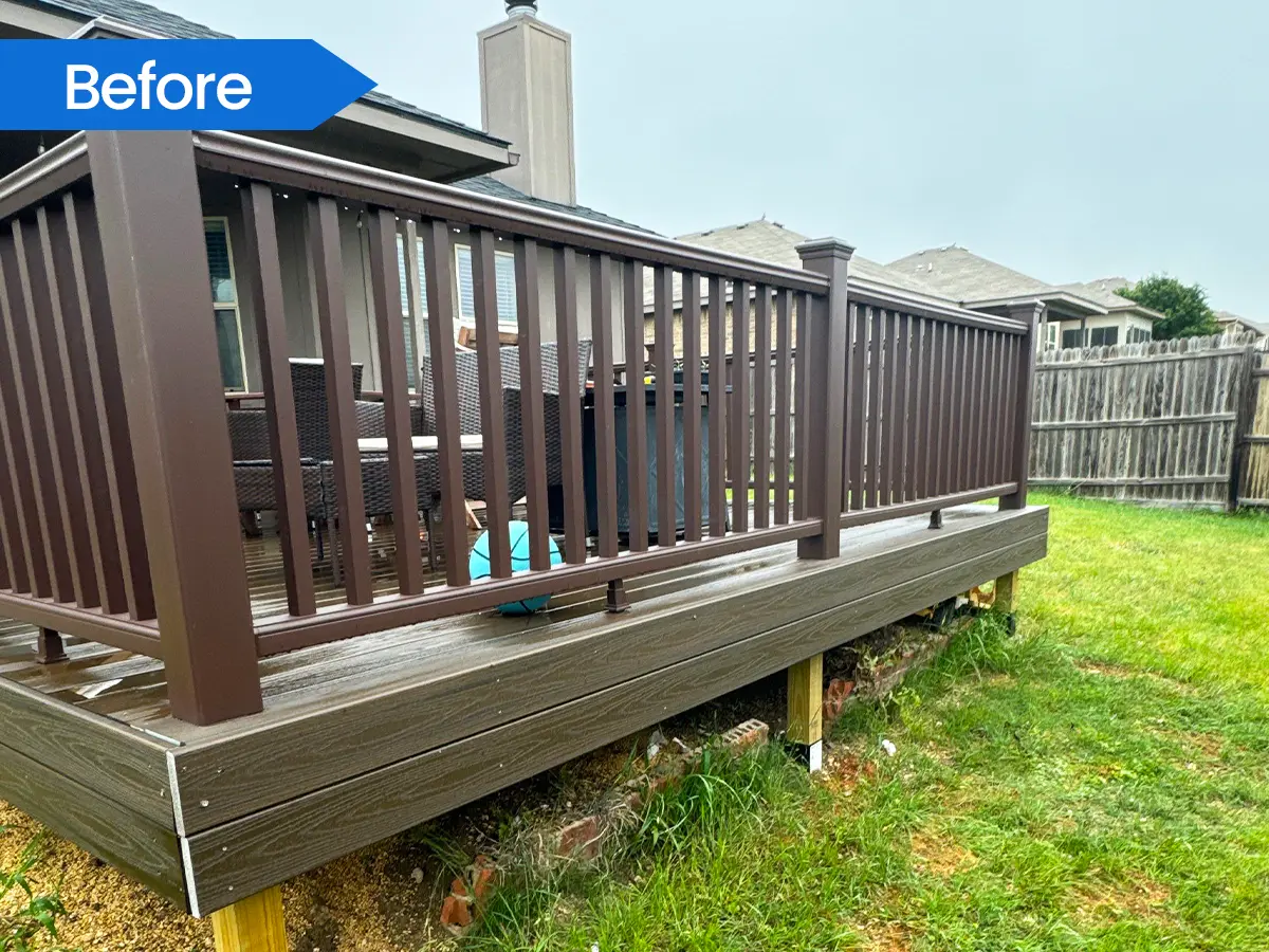 Elevated wooden deck with dark brown railings and a built-in bench in a backyard.