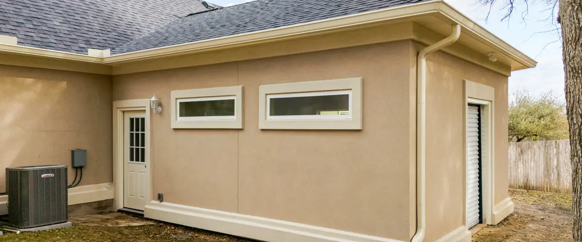 Modern stucco ADU exterior with low-profile windows, new roof, and HVAC system installation