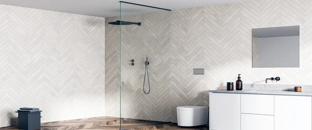 Modern walk-in shower with glass panel and herringbone tile wall