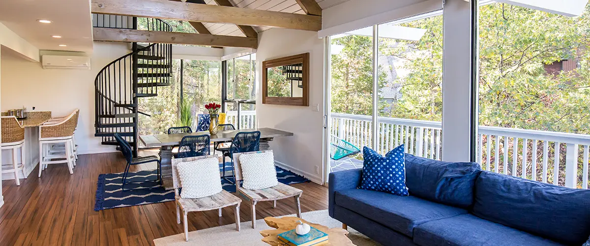 Open concept living space with spiral staircase and large windows