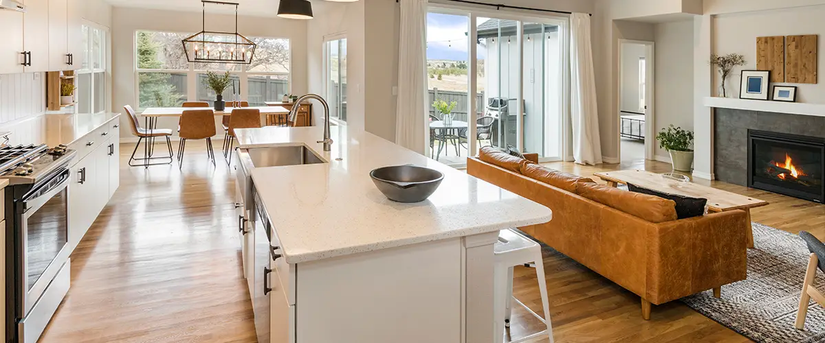 Bright kitchen and dining area with white cabinets and fireplace