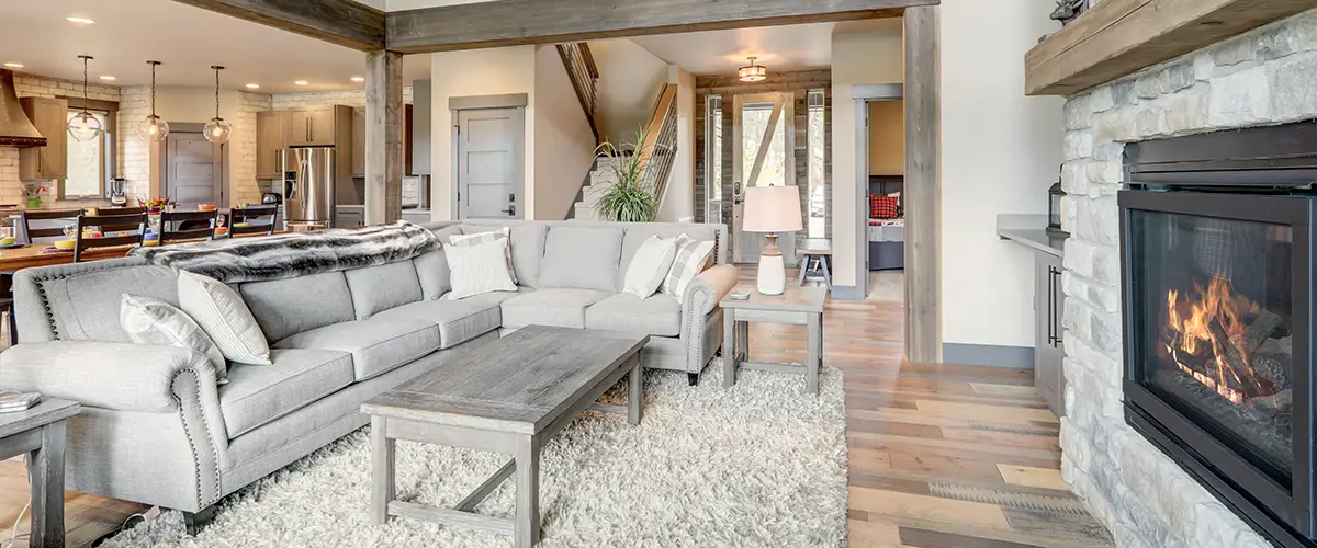 Open concept living space with sectional sofa and stone fireplace