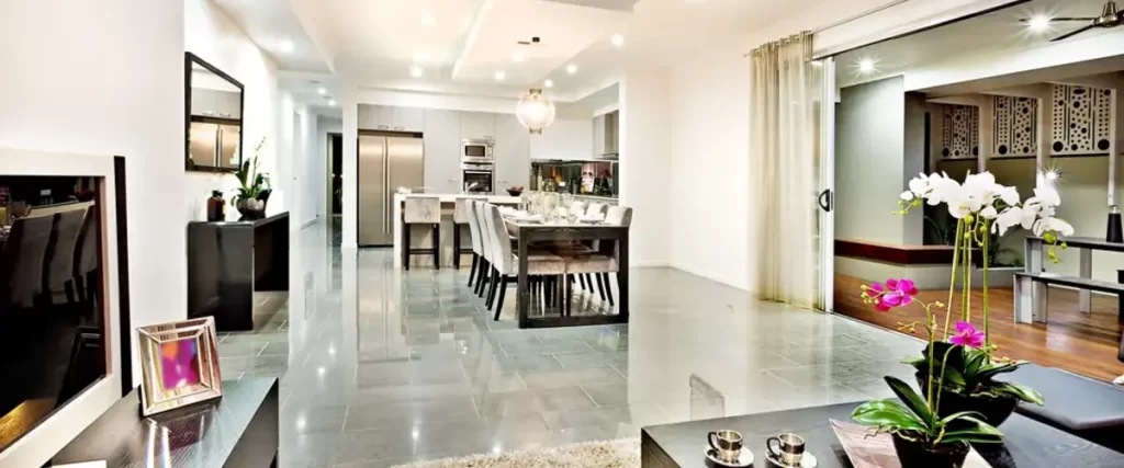 Contemporary open-plan living area with sleek kitchen, dining set, and modern lighting.