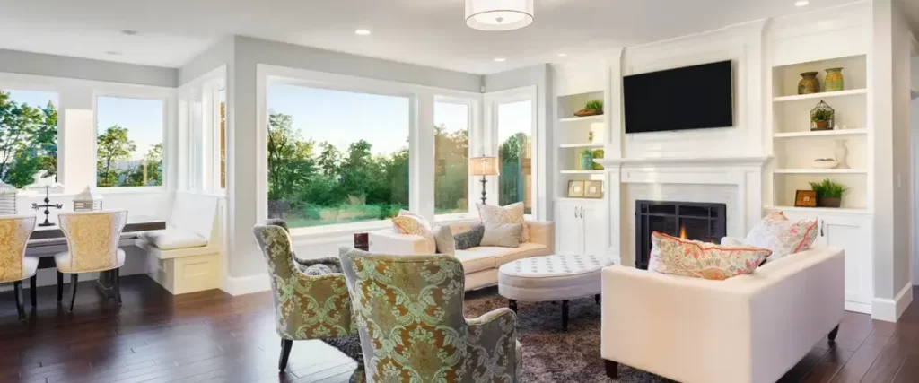 Bright living room with large windows, white decor, and scenic outdoor views.