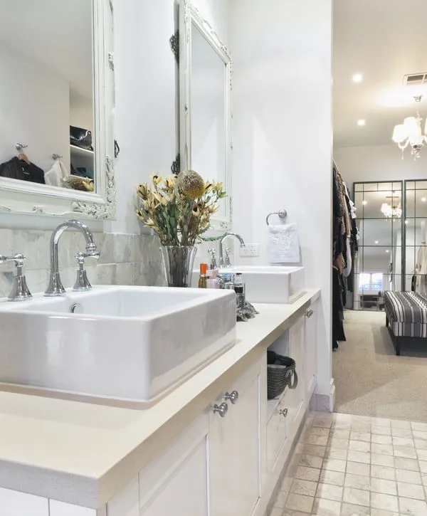 Bright, luxurious primary bathroom remodel featuring a double vessel sink vanity, ornate mirrors, and an entrance to a walk-in closet in a Georgetown, TX home.