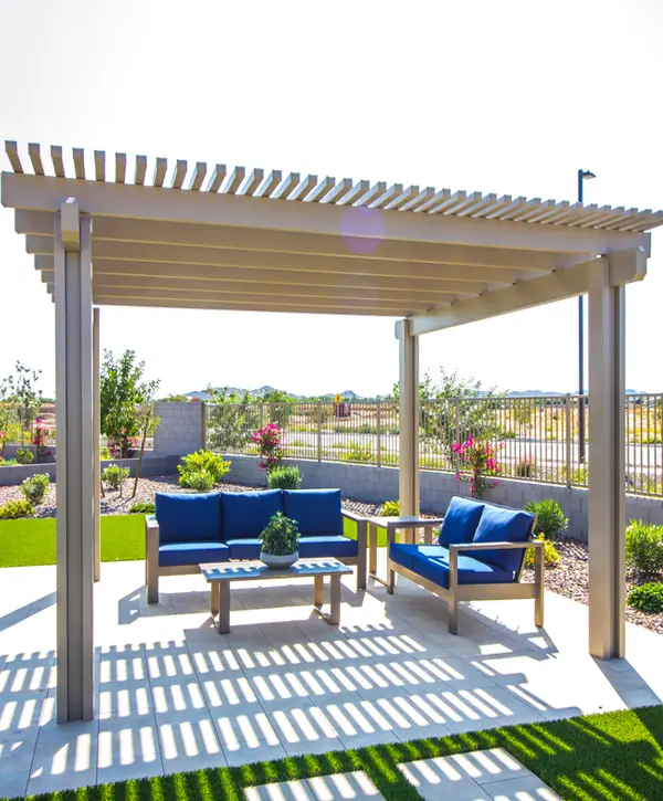 A modern tan aluminum pergola installed by a professional pergola builder in Temple, TX, shading a blue outdoor sofa set.
