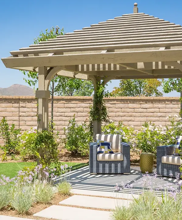 A custom wooden pergola installed by a professional pergola builder in Harker Heights, TX, featuring comfortable outdoor seating on a sunny patio with lush landscaping.