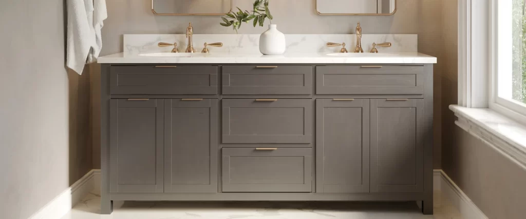 A wide modern vanity in charcoal grey featuring a white marble countertop, double sinks, and elegant gold faucet fixtures and drawer pulls.