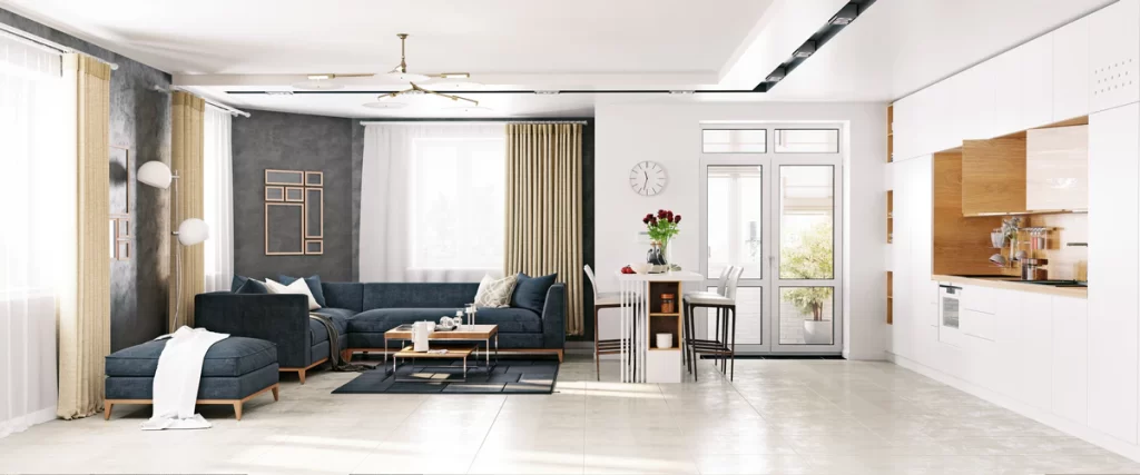 An expansive open-concept living space and kitchen featuring bright white walls, a navy blue sectional sofa, and polished light gray tile flooring.