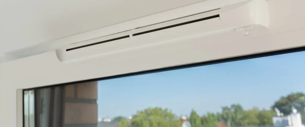 Close-up of a white window frame with an integrated trickle vent to improve home energy efficiency and airflow.