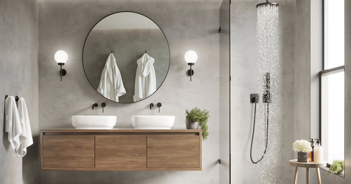 A professional bathroom renovation showing a floating wooden vanity, double vessel sinks, a large round mirror, and a rainfall shower, illustrating how to choose a bathroom remodeling contractor.