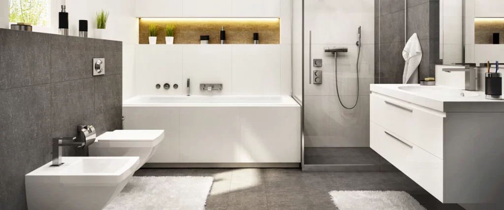 A sleek white and grey modern bathroom with a double vanity, large mirror, and recessed lighting in a stone-accented shelf.