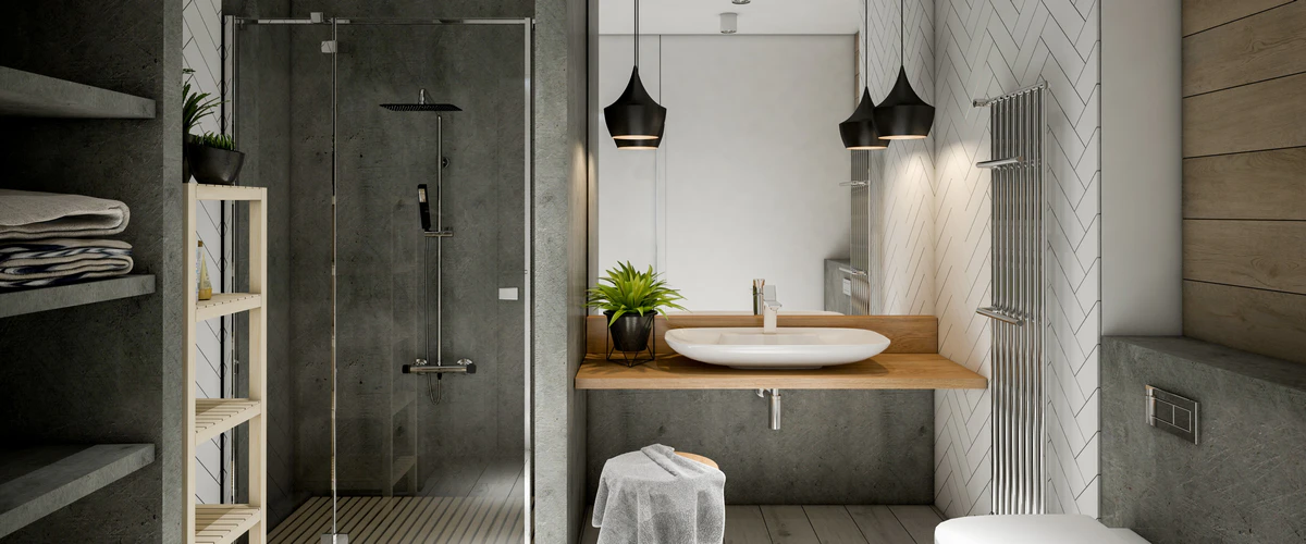 Industrial bsthroom design featuring a concrete-style shower wall, a white vessel sink on a floating wooden vanity, and black pendant lighting against a white herringbone tile wall.