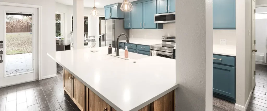Blue kitchen cabinet remodel with quartz countertops and large peninsula seating area