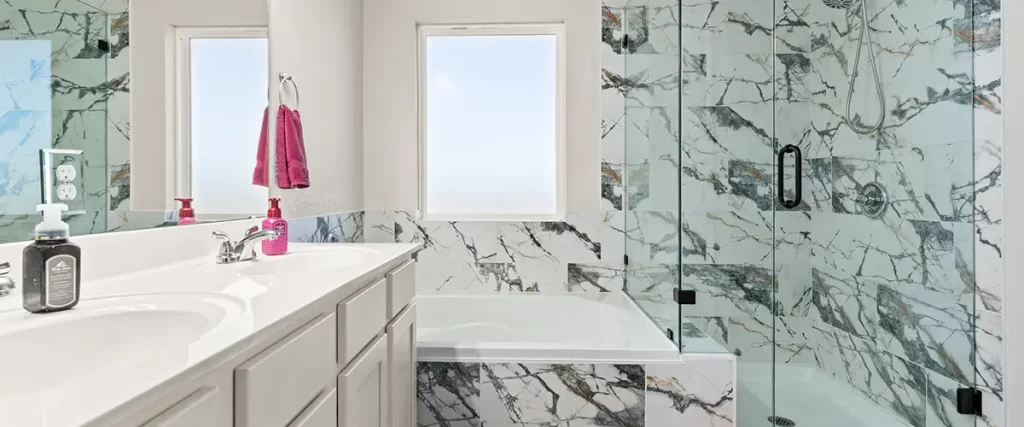 Luxury bathroom renovation with marble tile shower, soaking tub, and frameless glass enclosure
