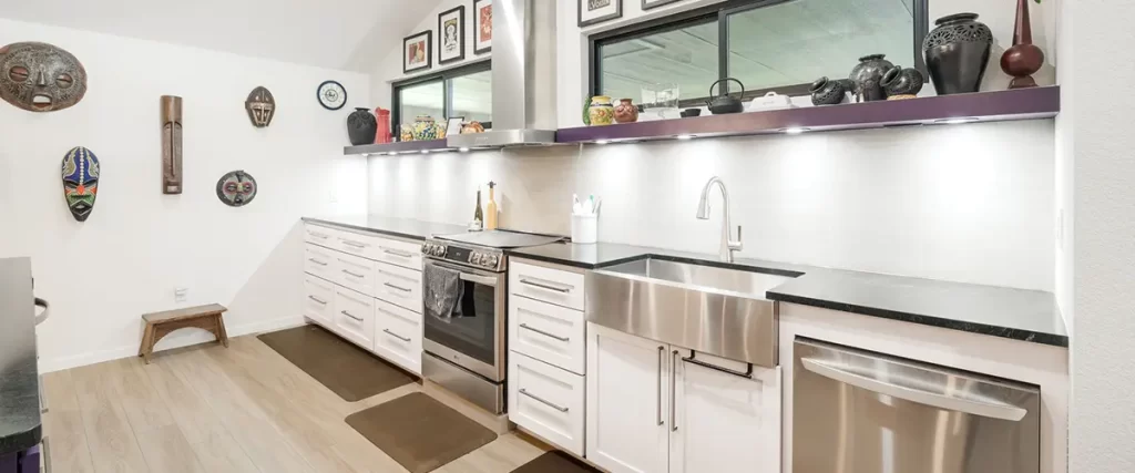 Modern galley kitchen remodel with farmhouse sink, stainless appliances, and custom white cabinetry