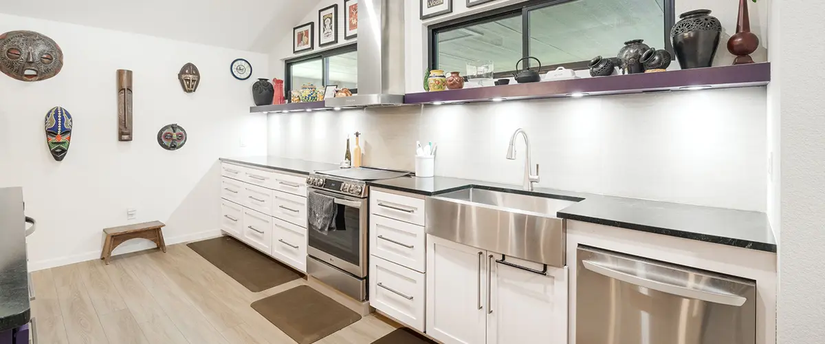 Modern galley kitchen remodel with farmhouse sink, stainless appliances, and custom white cabinetry