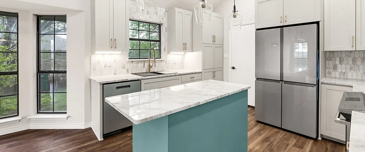 Modern white kitchen remodel with marble island, custom cabinets, and pendant lighting