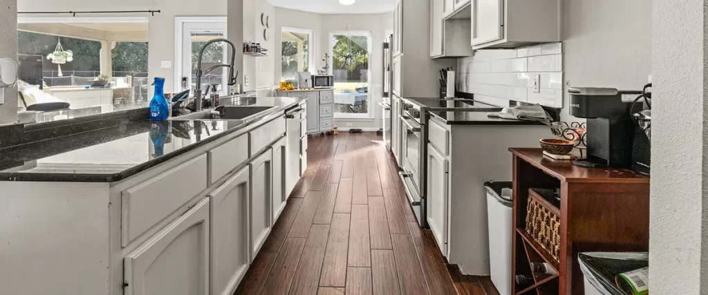 Open-concept kitchen renovation with blue cabinets, quartz countertops, and pendant lighting