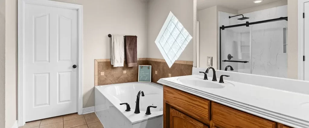 Spacious master bathroom with soaking tub, dual vanity, and walk-in marble shower