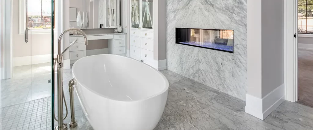 Luxury bathroom remodel with freestanding tub, marble feature wall, and built-in fireplace