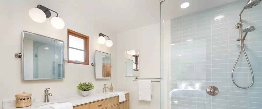 Modern bathroom remodel with double vanity, walk-in glass shower, and custom tile flooring