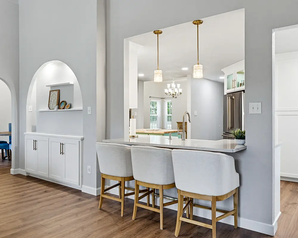 Open-concept kitchen remodel with breakfast bar, custom cabinetry, and modern lighting for functional living.