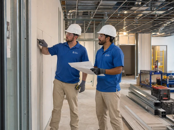 Commercial remodeling crew reviewing wall layout during interior buildout
