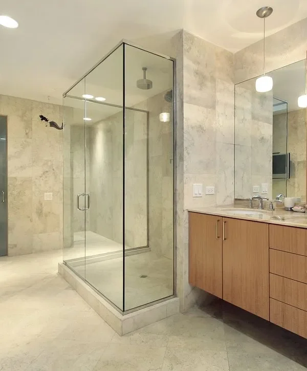 Walk-in glass shower remodel with marble-look tile and modern fixtures