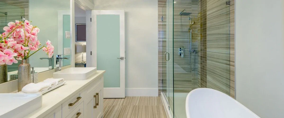 Luxury primary bathroom with frameless glass shower and double vessel sinks