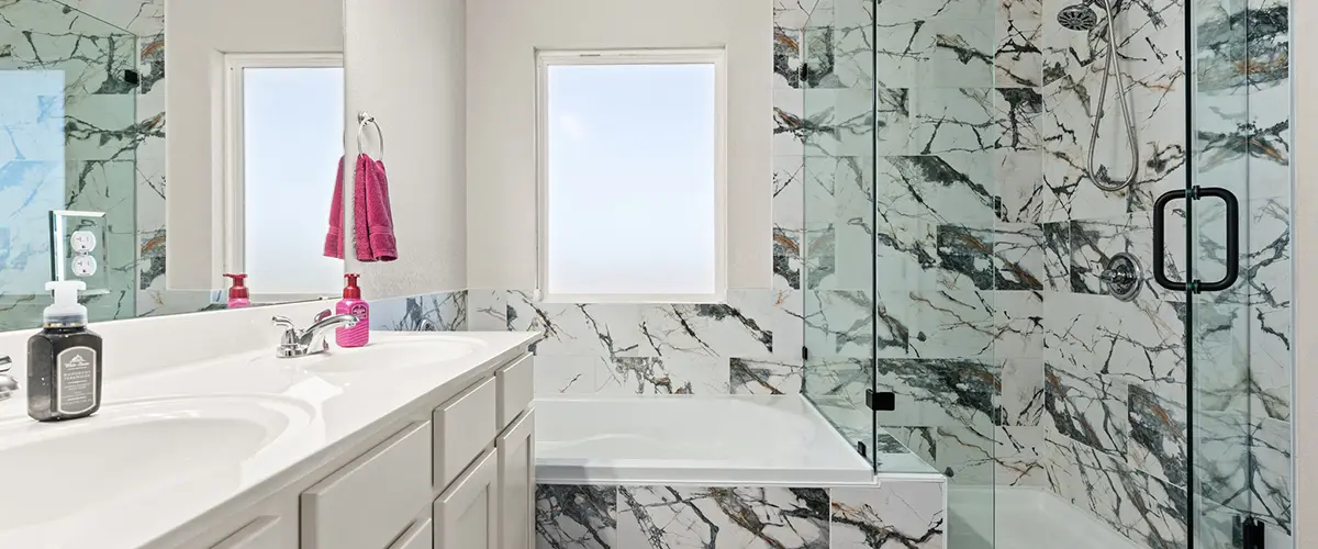 Bathroom remodel with double vanity, soaking tub and glass shower with marble-look tile