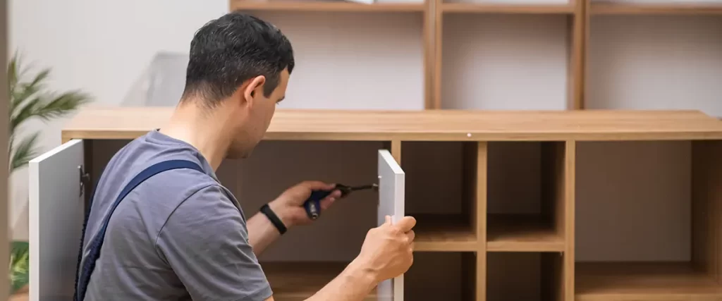Cabinet installer assembling custom kitchen cabinetry during a home remodeling project