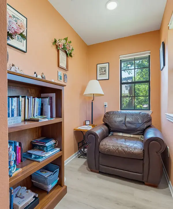 Cozy home addition reading room with built-in bookshelf, seating and large window