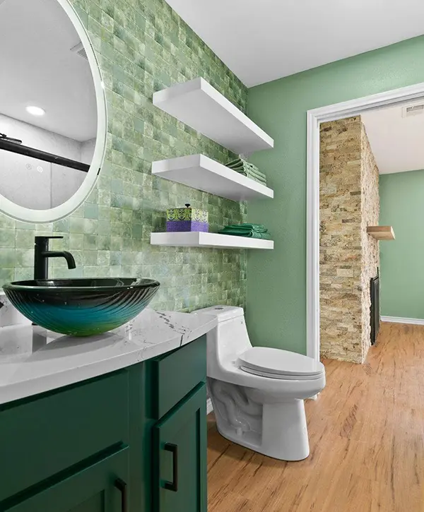 Home addition bathroom with green tile, modern vanity, vessel sink and floating shelves