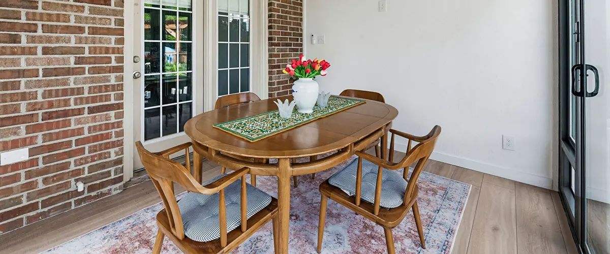 Home addition dining room with exposed brick, wood ceiling, sliding doors and modern finishes