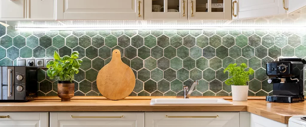 Modern kitchen remodel with white cabinets, wood countertops and green hexagon tile backsplash