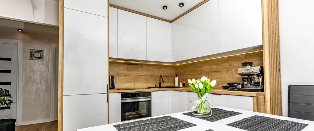Modern remodeled kitchen with white cabinets, wood countertops and built-in appliances
